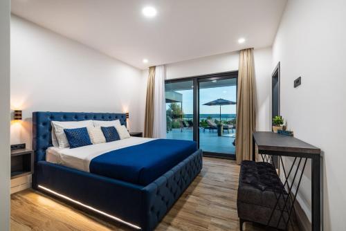 a bedroom with a blue bed and a balcony at Luxury Villa Royal Hill with 34 m2 pool in Maslenica
