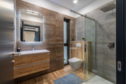 a bathroom with a sink and a glass shower at Luxury Villa Royal Hill with 34 m2 pool in Maslenica