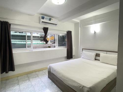 a bedroom with a large bed and a window at Nice to CU Guest house in Patong Beach