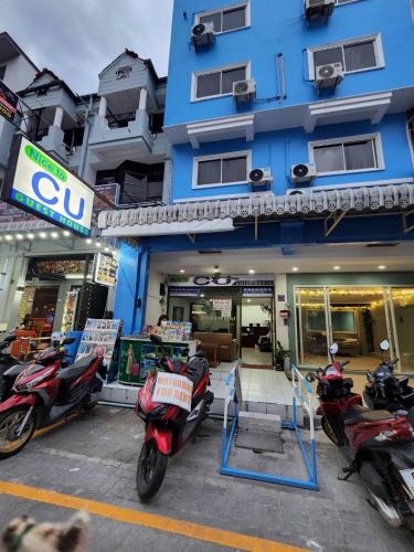 a group of motorcycles parked in front of a building at Nice to CU Guest house in Patong Beach