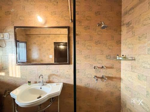 a bathroom with a sink and a mirror at Hotel Sunny Cot - Free Mall Shuttle and Parking in Mussoorie