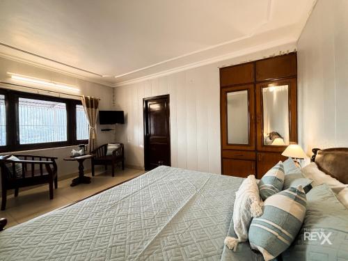 a bedroom with a bed and a desk and a chair at Hotel Sunny Cot - Free Mall Shuttle and Parking in Mussoorie