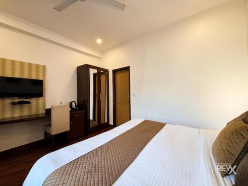 a bedroom with a bed and a flat screen tv at Hotel Sunny Cot - Free Mall Shuttle and Parking in Mussoorie