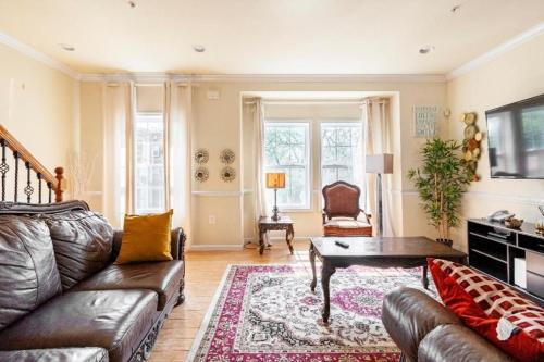 a living room with a couch and a table at Luxury & Cherished Private Room in DC in Washington, D.C.