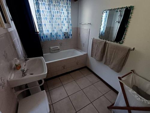 a bathroom with a tub and a sink and a bath tub at Family beachfront cottage in Tergniet
