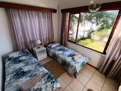 a bedroom with two beds and a window at Family beachfront cottage in Tergniet