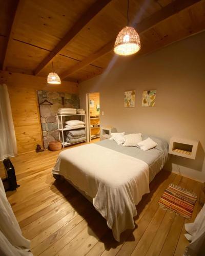 a bedroom with a large bed and two lights at El Silencio, Lozano - Jujuy in Lozano