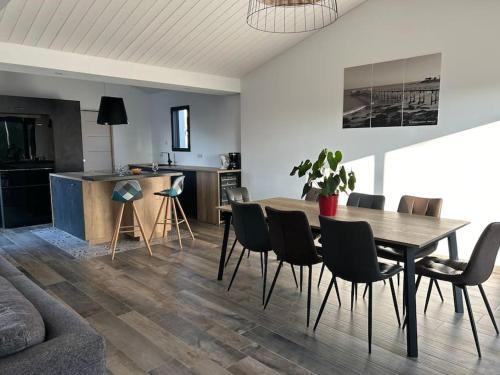 un salon avec une table et des chaises de salle à manger dans l'établissement L'Epine, à LʼÉpine