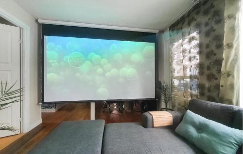 a large screen in a living room with a couch at Stunning Home In Gnesta With Wifi in Gnesta