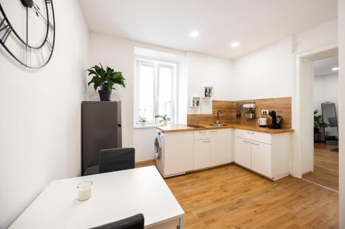 cocina con armarios blancos, fregadero y mesa en Appartamento Tanja Trieste, en Trieste
