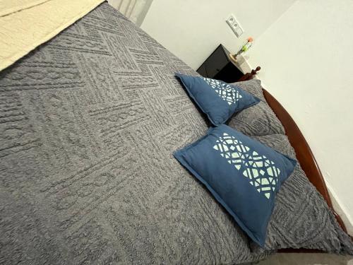 a bed with blue pillows on top of it at Agadir House 2 in Agadir