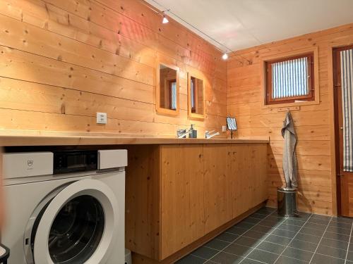 a washing machine in a room with wooden walls at Casa Seglias in Brigels