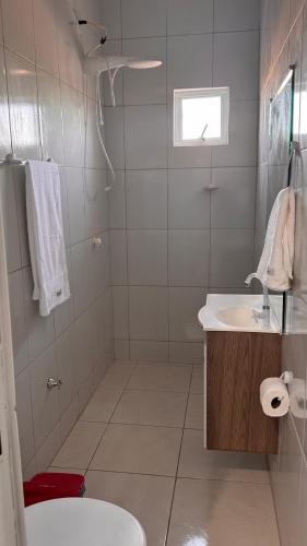 a white bathroom with a sink and a toilet at Mirante Paraíso Residencial in Jijoca de Jericoacoara