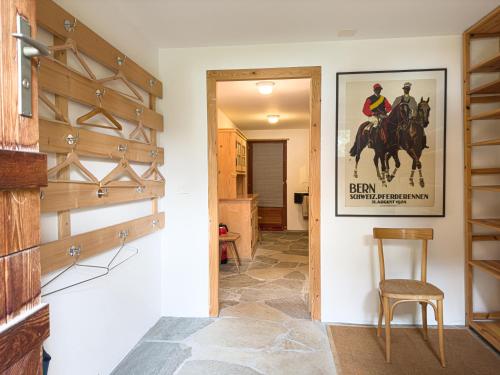 a hallway with a horse poster on the wall at Casa Seglias in Brigels
