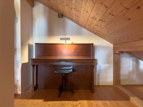 a wooden desk with a stool in front of it at Casa Seglias in Brigels