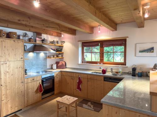 a large kitchen with wooden cabinets and a counter top at Casa Seglias in Brigels