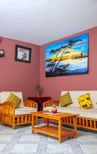 a living room with two couches and a table at Lakeshore Bed and Breakfast in Entebbe