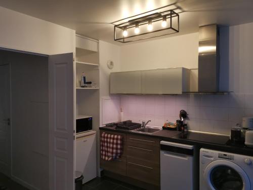 une cuisine avec un évier et une machine à laver dans l'établissement Appartement Cosy à Clichy, avec parking ,proche Paris!, à Clichy