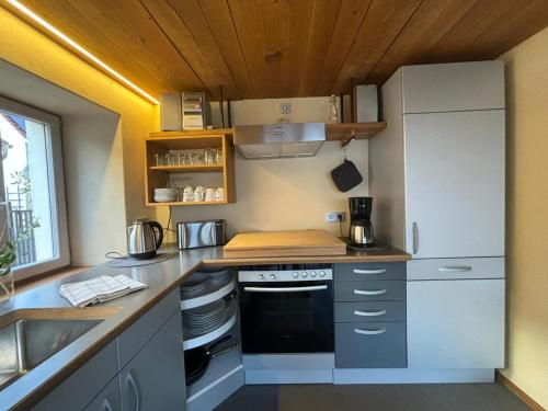 a small kitchen with a stove and a refrigerator at Ferienhaus Streuglück in Oberstreu
