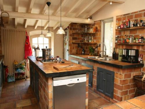 une cuisine avec un comptoir et un mur en briques dans l'établissement Villa L'Authentique, vue a 360 degrés et piscine privée, à Ménerbes