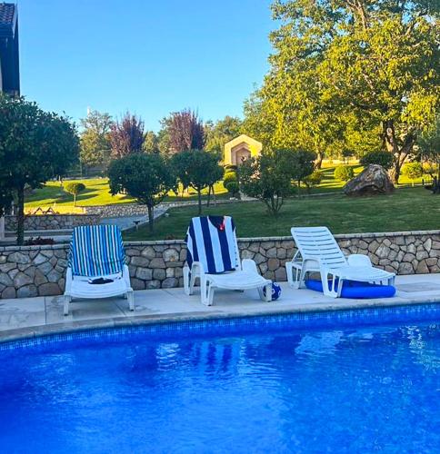 two blue and white chairs next to a swimming pool at Residence Herzegovina in Široki Brijeg