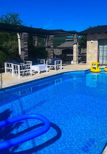 a large swimming pool with chairs and an umbrella at Residence Herzegovina in Široki Brijeg