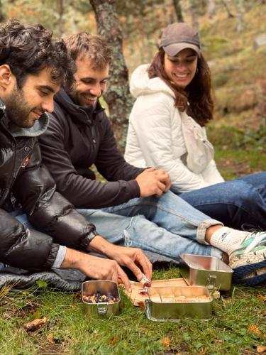 a group of three people sitting on the grass at Basecamps Cerdanya in Queixans