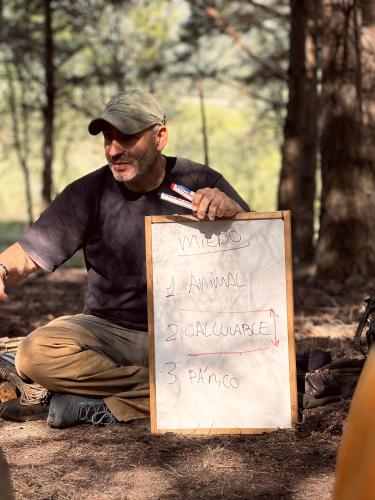 a man sitting on the ground next to a sign at Basecamps Cerdanya in Queixans