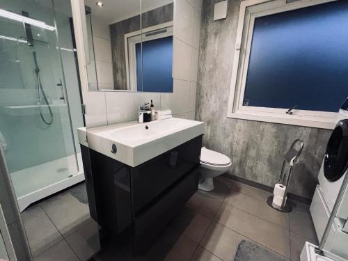 a bathroom with a sink and a shower and a toilet at Panorama view! Modern,Balcony/parking in Bodø