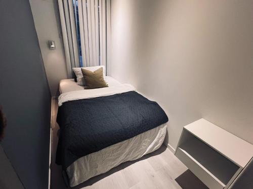 a small bedroom with a bed in a room at Panorama view! Modern,Balcony/parking in Bodø