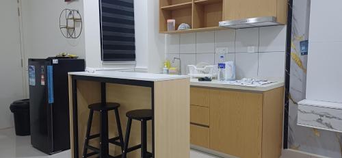a small kitchen with two stools and a counter top at HABITUS Elmina Denai Alam in Shah Alam