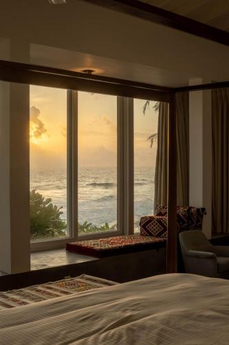 a bedroom with a view of the ocean at Villa Sayura in Boossa