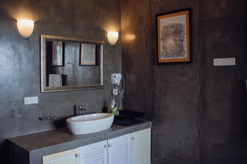 un baño con lavabo y espejo en Villa Sayura, en Busse