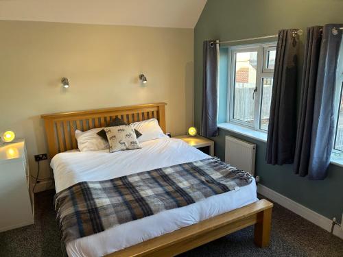 a bedroom with a bed and a window at 3 Bed Farnborough Air Accommodation in Farnborough