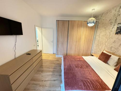 a bedroom with a large bed and a flat screen tv at Lipatti 15 Premium Apartments by GLAM APARTMENTS in Timişoara