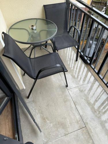 a glass table and chairs on a balcony at Lipatti 15 Premium Apartments by GLAM APARTMENTS in Timişoara