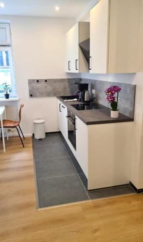 a kitchen with white cabinets and a stove top oven at Wohnung Ilz - im Zentrum, Parkplatz, Küche, getrennte Betten in Passau