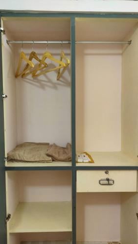 a walk in closet with yellow hangers at Pracheeta Homes in Trivandrum
