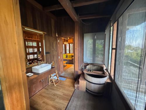 a bathroom with a tub and a sink and a tub at Mii Paa Aii มิ๊ ป๊ะ ไอ in Chiang Mai