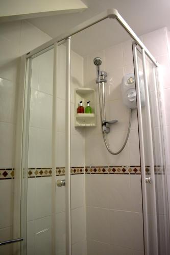 a shower with a glass door in a bathroom at Harrington Guest House in Newquay
