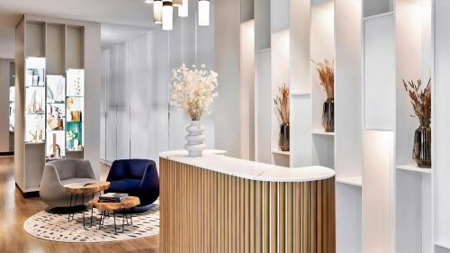 a lobby with chairs and a table with a vase on it at Alliance Palace Marriott in Batumi