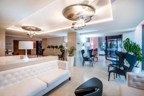 a living room with a white couch and chairs at Alliance Palace Marriott in Batumi