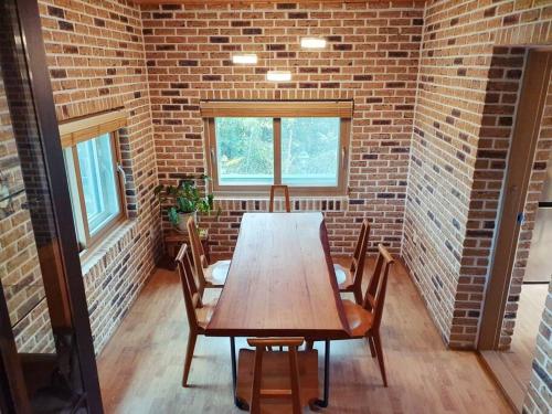 a table and chairs in a room with a brick wall at Executive Home in Jeju in Jeju