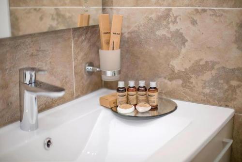 a tray with five bottles on a counter next to a sink at Alliance Palace Marriott in Batumi