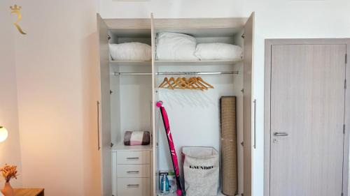 a walk in closet with white shelves and a door at Cozy 1BR Apartment with Private Balcony - Prime Yas Island Location Near Yas Mall in Abu Dhabi