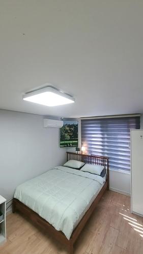 a bedroom with a bed and a large window at Incheon Intl Airport ANN Guest House in Incheon