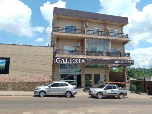 two cars parked in front of a building at Elite Flat Hotel in São Gabriel da Cachoeira