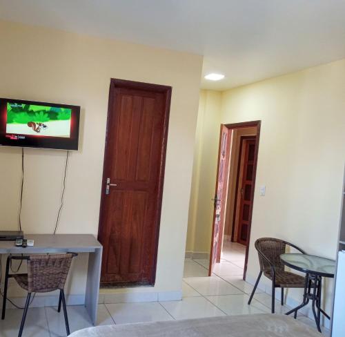 a room with a table and a tv on the wall at Elite Flat Hotel in São Gabriel da Cachoeira