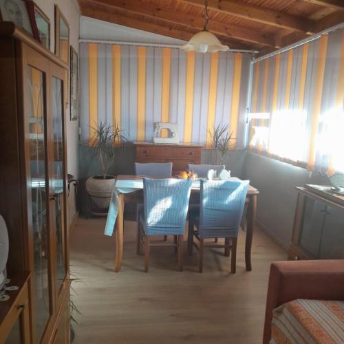 a dining room with a table and blue chairs at Sarah Delight in Pýrgos