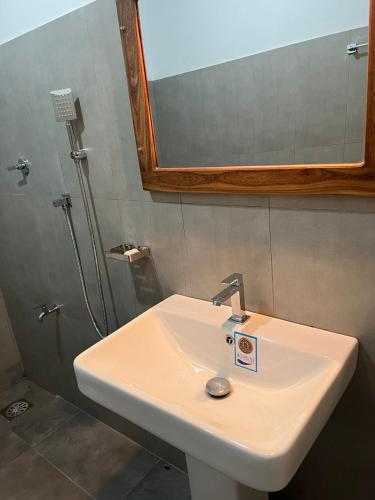a white sink in a bathroom with a mirror at Hotel Nagas Ella in Gonagaldeniya